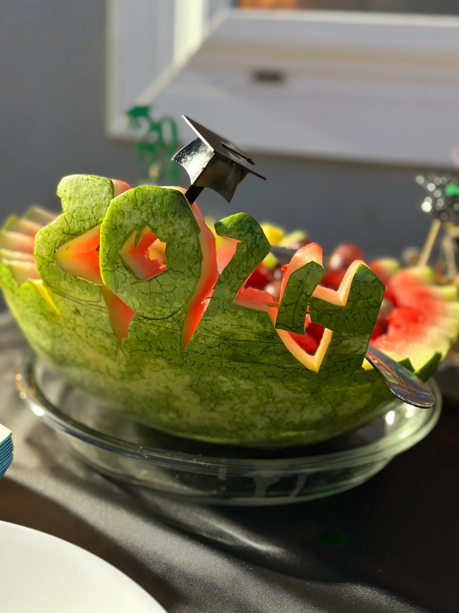 A carved fruit centerpiece decorated with the number 2024.
