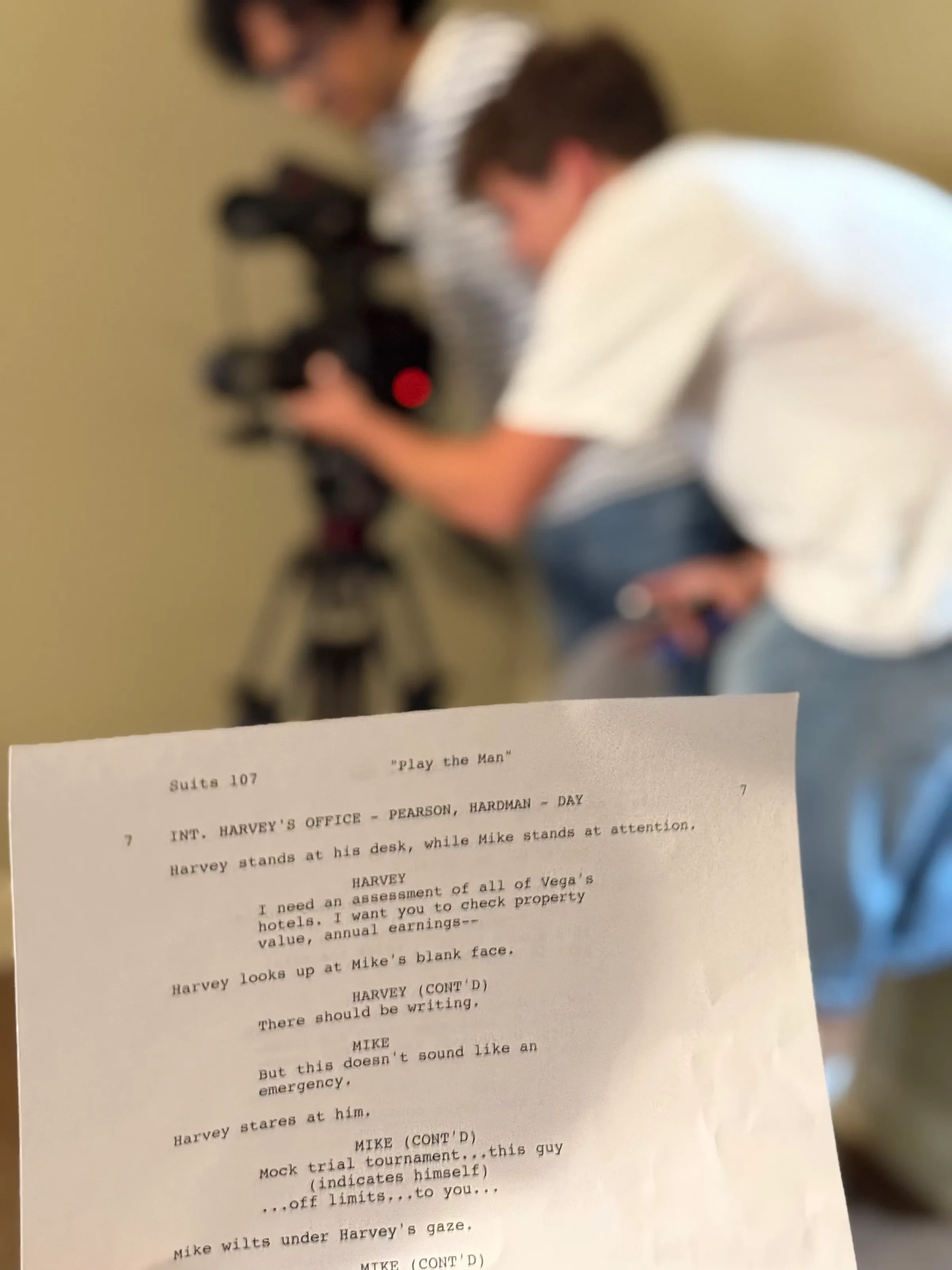 A printed script in the foreground of a camera rehearsal.