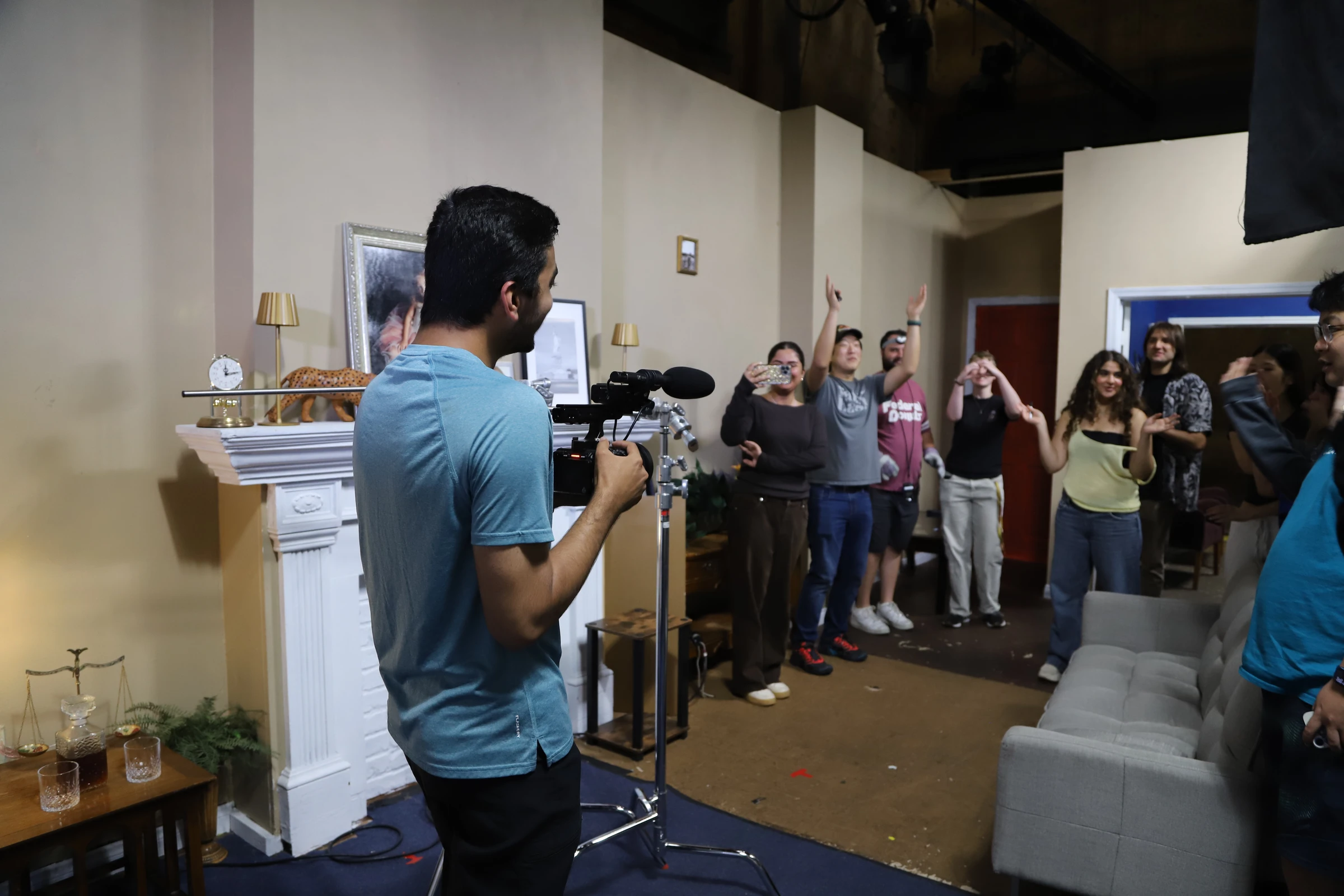 A camera operator filming a group gathered inside a classroom.