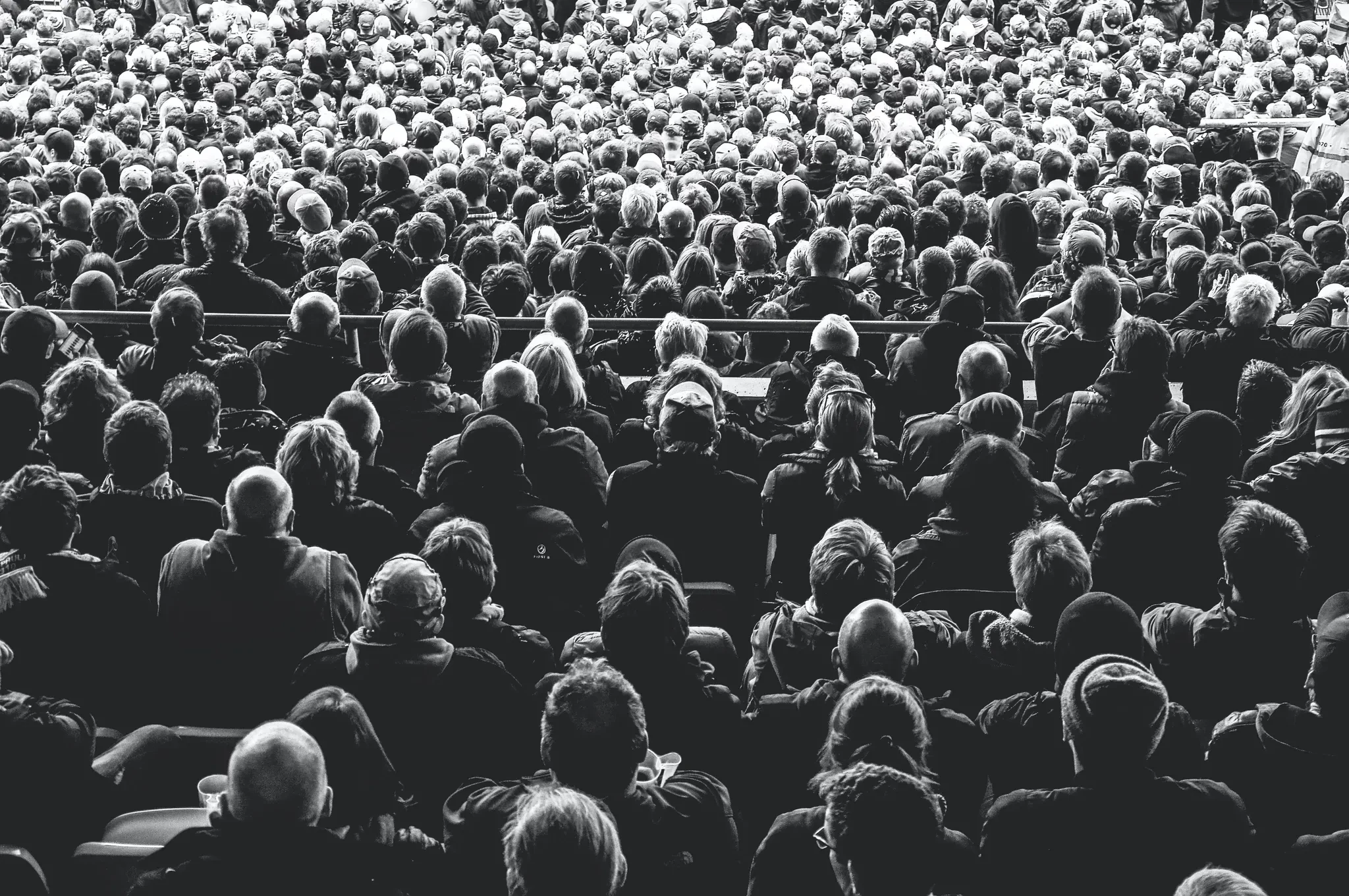 A large crowd viewed from behind in black and white.