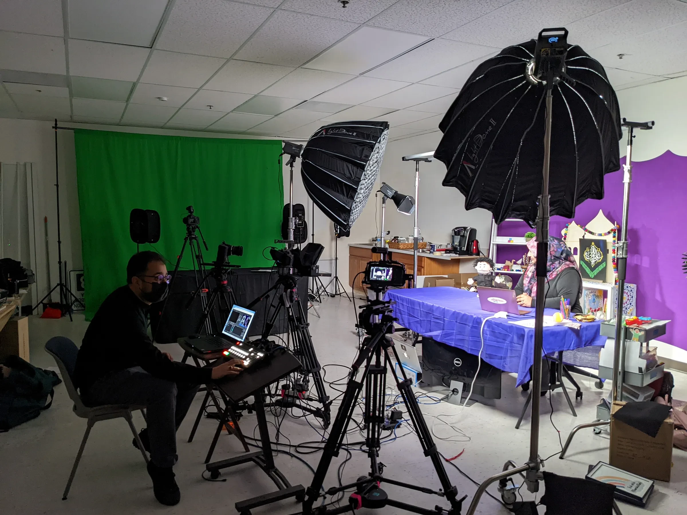 A podcast recording room with cameras, microphones, and studio lights.