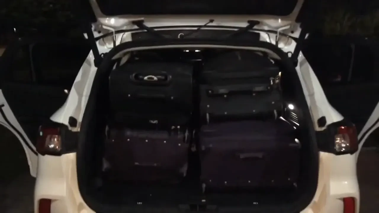 The open trunk of a car packed with luggage.